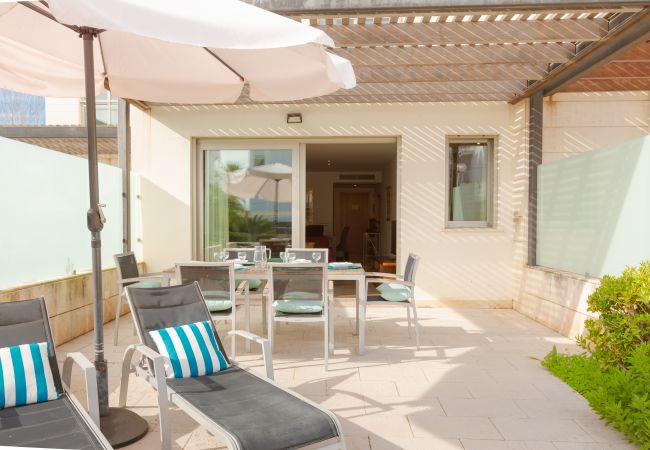 Terraza del apartamento con sombrilla y acceso a la piscina