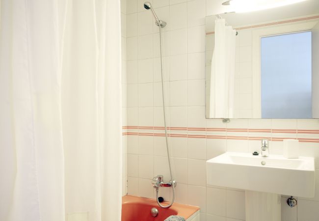 Badezimmer mit Badewanne, Waschbecken und Spiegel