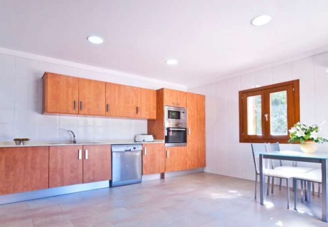 Kitchen with dishwasher, oven, microwave and dining table