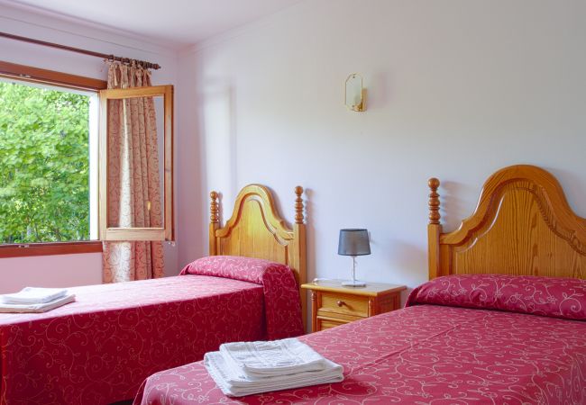 Room with 2 single beds with sheets and towels