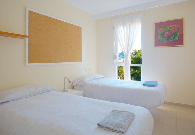 Camas individuales en dormitorio con gran ventana